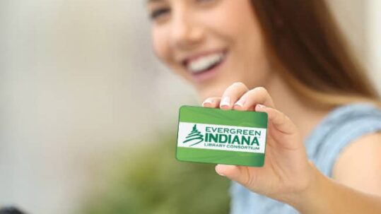 Woman holding an Evergreen Indiana card smiling