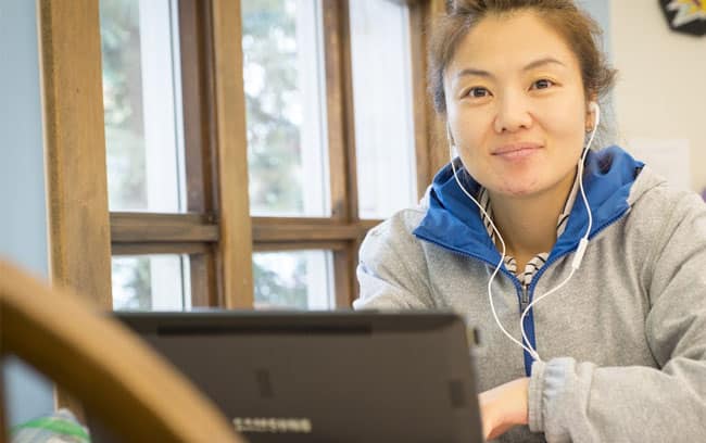 Teenage girl wearing headphones using a study room