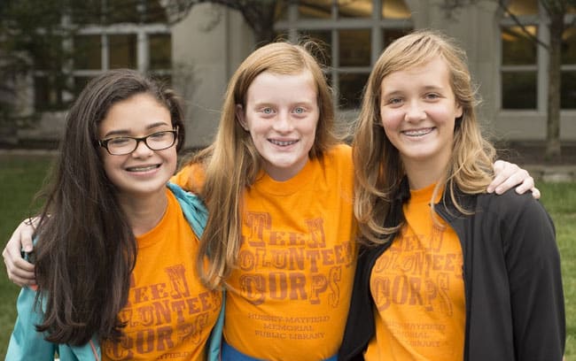 Three teenaged girls getting involved in the teen volunteer corps