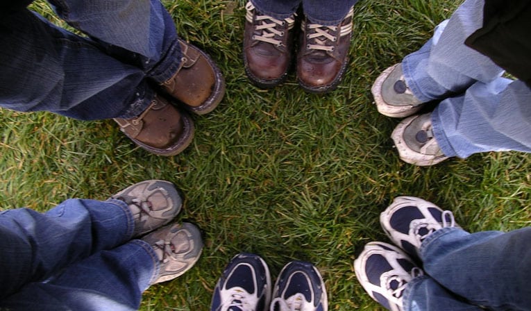Photo of people's feet standing together in a circle