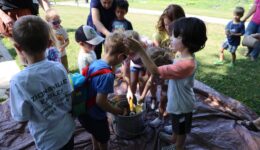 Children and caregivers planting seeds