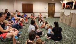 Children and caregivers watching a puppet show