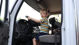 Young boy sitting in driver's seat of big truck