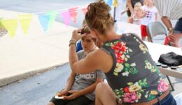 Woman face painting a boy's face