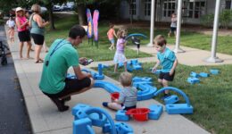 Caregiver taking photo of children playing with foam blocks