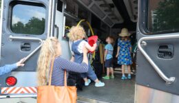 Caregiver helping children inside the Creekstomper truck