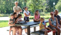 Caregivers and children listening to a story at the park