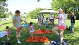 Children, caregivers and librarians doing yoga at the park