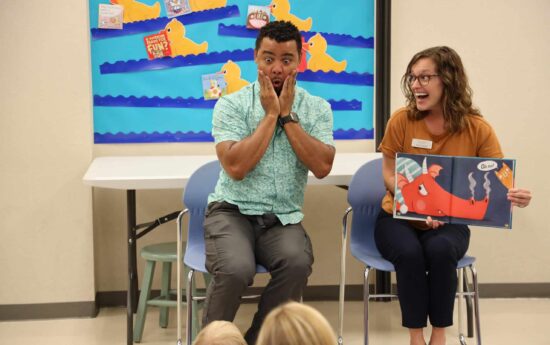 Adults reading a book in ASL during ASL storytime