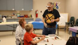 Children, caregivers and librarians work on a train craft with Mr. Mike