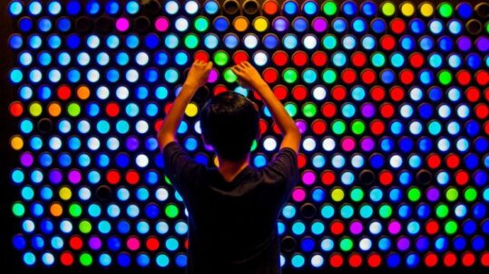 a young boy in front of an Everbright light up wall