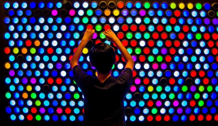 a young boy in front of an Everbright light up wall