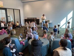 Miss Becky marches to the drum with kiddos at All Ages Storytime!