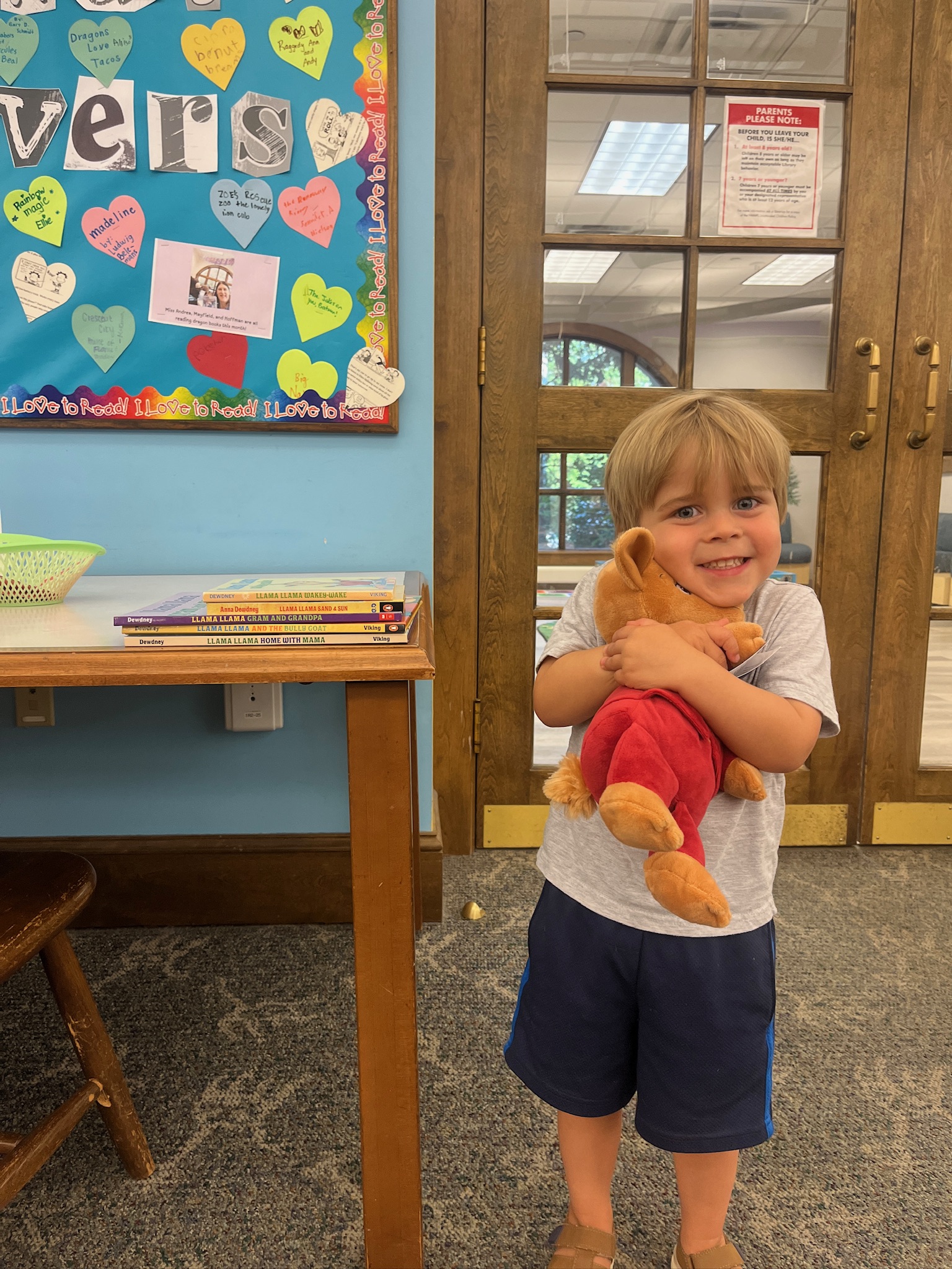 Boy hugging stuffed llama 