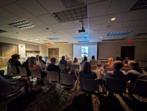 Image of patrons who attended program, looking at a projector screen.