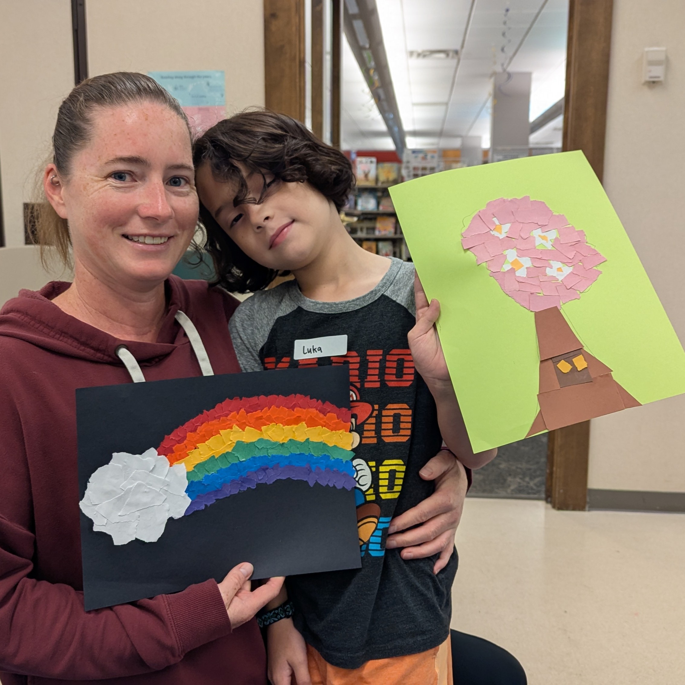 Mom and son holding up their art creations