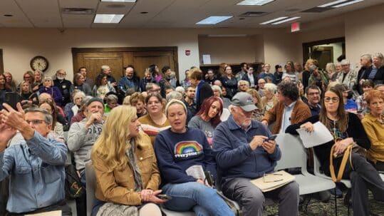 A room full of seated people at a library board meeting.